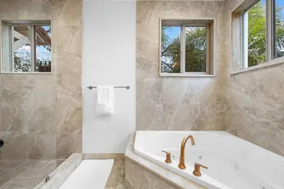 a bathroom with a tub and a shower with windows at The Betty A Glam Getaway in Fort Lauderdale in Fort Lauderdale