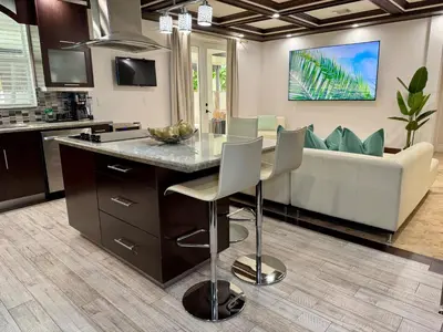 a kitchen and living room with a table and a couch at Miami Getaway Heated Pool Villa with Mini Golf & BBQ in Miami