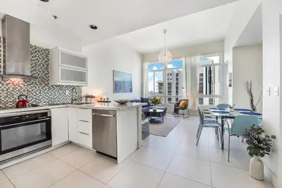 a kitchen and living room with a table and chairs at Castle Ph11 Penthouse with Balcony, Free Parking, Pool, Tennis, Beach Access in Miami Beach