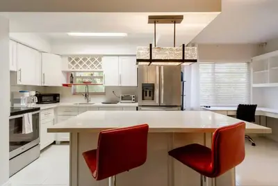 a kitchen with a large island with red chairs at Perfect Beach Escape 1BD/1Bath Close to Everything in Fort Lauderdale