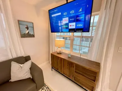 a living room with a large tv and a couch at Perfect Beach Escape 1BD/1Bath Close to Everything in Fort Lauderdale