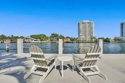 two chairs and a table on a dock near the water at Vistamar Waterfront Beach Abode -Walk to the Beach in Fort Lauderdale