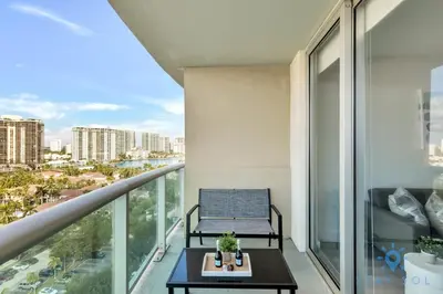 a balcony with a bench and a view of the city at Beachside Bliss: 1BR Retreat Amenities in Sunny Isles Beach