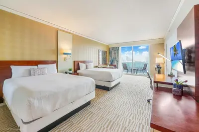 a hotel room with two beds and a balcony at 5th Floor Luxury Suite at Trump Int Resort in Sunny Isles Beach