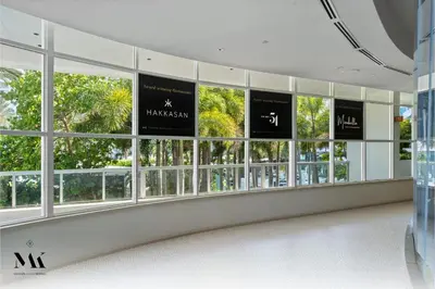 a group of windows in a building with palm trees at FontaineBleau Resort Balcony w Ocean + Bay View in Miami Beach
