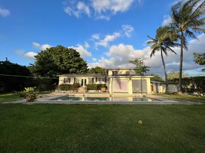a white house with a palm tree and a yard at Villa Rustica 5 Bedroom 3 Bath with Pool Next to River 1800 in Miami