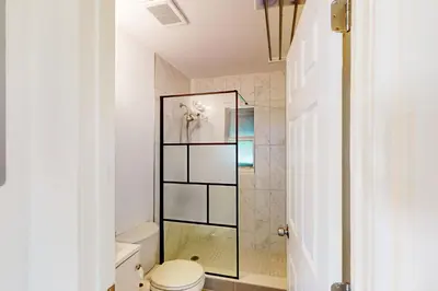 a bathroom with a toilet and a glass shower at Palm Shadow Sanctuary in Fort Lauderdale