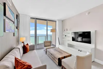 a living room with a couch and a table at Beachfront Escape Pool Gym Stunning Views 30th floor in Hallandale Beach