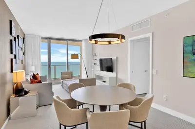 a living room with a table and chairs at Beachfront Escape Pool Gym Stunning Views 30th floor in Hallandale Beach