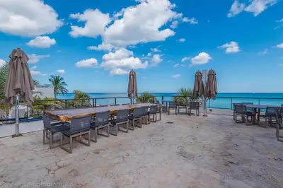a table with chairs and umbrellas on the beach at Beachfront Escape Pool Gym Stunning Views 30th floor in Hallandale Beach