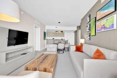 a living room with a white couch and a tv at Beachfront Escape Pool Gym Stunning Views 30th floor in Hallandale Beach