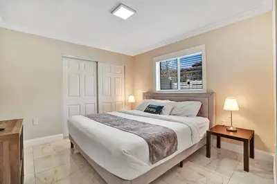 a bedroom with a large bed and a window at Luxury 4BR & 4BA Villa Heated Pool Minutes To Beach in Hollywood