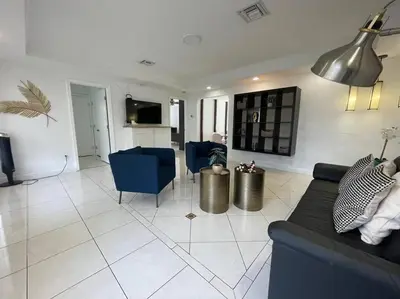 a living room with a couch and blue chairs at Stylish Home close to everything in Hollywood