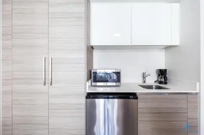 a kitchen with white cabinets and a stainless steel refrigerator at New Studio - Hollywood Beach Bliss for 2 in Hollywood