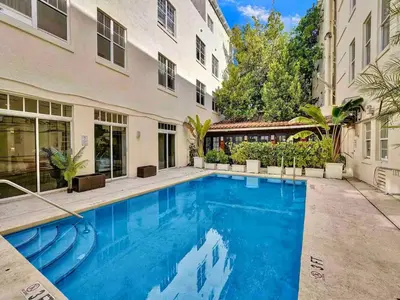 a swimming pool in front of a building at Park Place South of Fifth in Miami Beach