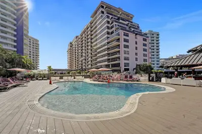 a large swimming pool in a city with tall buildings at Huge 2BD Miami beach with beach service -720 in Miami Beach