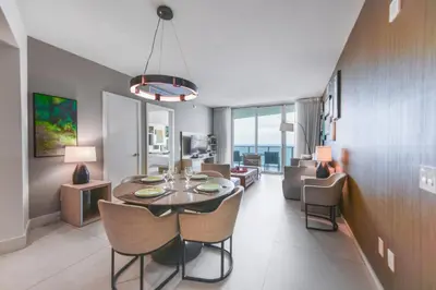 a dining room and living room with a table and chairs at Beachside Condo with a Mesmerizing Ocean View in Hollywood
