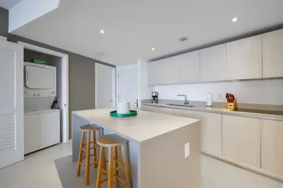a kitchen with a counter and two bar stools at Beachside Condo with a Mesmerizing Ocean View in Hollywood