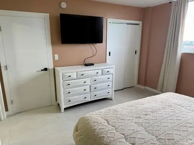 a bedroom with a bed and a television on a dresser at Ocean Reserve Condo by FlatsAway in Miami Beach