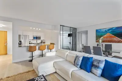 a living room with a white couch and a kitchen at myClub at Brickell Bay in Miami