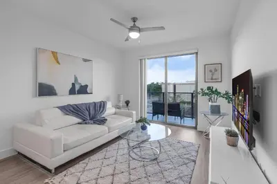 a white living room with a white couch and a window at Modern 1 Bedroom In The Heart Of Downtown Doral in Hialeah Gardens