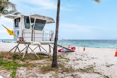 a lifeguard boat on the beach next to a palm tree at Bayshore Breeze 2 in Fort Lauderdale