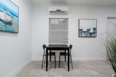 a black table and chairs in a room with paintings at Bayshore Breeze Free Parking 5 in Fort Lauderdale