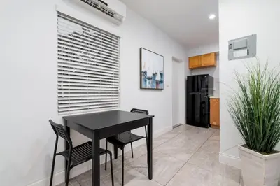 a black table and chairs in a kitchen with a refrigerator at Bayshore Breeze Free Parking 5 in Fort Lauderdale