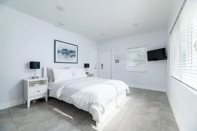 a white bedroom with a bed and a tv at Bayshore Breeze 8 in Fort Lauderdale