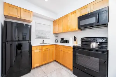a kitchen with black appliances and wooden cabinets at Bayshore Breeze Free Parking 9 in Fort Lauderdale