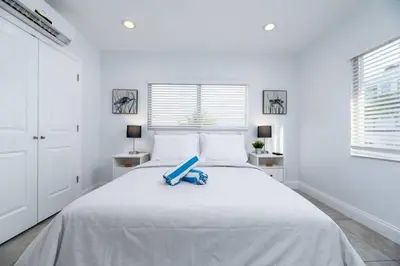a white bedroom with a bed with a blue item on it at Bayshore Breeze Free Parking 9 in Fort Lauderdale