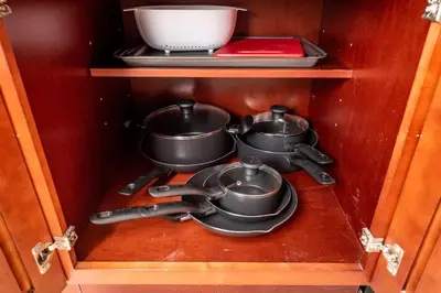a cabinet with three pots and pans in it at Ocean Breeze Free Parking Apt 1 in Fort Lauderdale