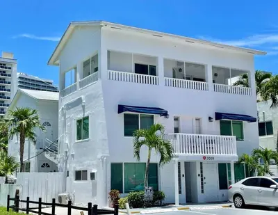 a white house with a car parked in front of it at Ocean Breeze Free Parking Apt 1 in Fort Lauderdale
