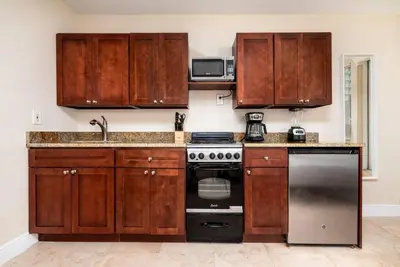 a kitchen with wooden cabinets and a stove at Ocean Breeze Free Parking Apt 1 in Fort Lauderdale