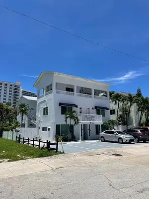 a white building with a car parked in a parking lot at Ocean Breeze Free Parking Apt 2 in Fort Lauderdale