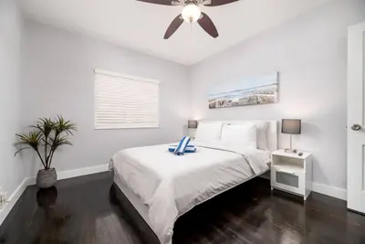 a white bedroom with a bed and a ceiling fan at Ocean Breeze Free Parking Apt 5 in Fort Lauderdale