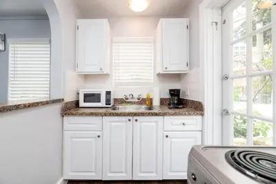 a white kitchen with a sink and a microwave at Ocean Breeze Free Parking Apt 5 in Fort Lauderdale