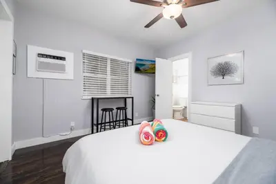 a white bedroom with a bed and a ceiling fan at Ocean Breeze Paradise Apt 5A in Fort Lauderdale