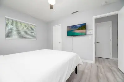 a white bedroom with a white bed and a window at Short Walk to Wilton Drive Apt1 in Fort Lauderdale