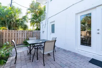 a patio with a table and chairs and a fence at Short Walk to Wilton Drive Apt3 in Fort Lauderdale