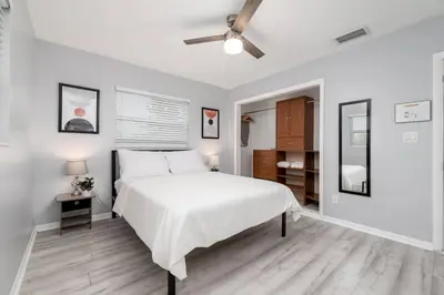 a bedroom with a white bed and a ceiling fan at Short Walk to Wilton Drive Apt4 in Fort Lauderdale