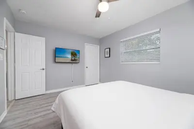 a white bedroom with a bed and a window at Short Walk to Wilton Drive Apt4 in Fort Lauderdale