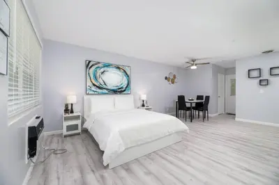 a white bedroom with a bed and a dining room at Just Off Wilton Drive Apt 2 in Fort Lauderdale