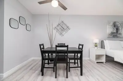a dining room with a table and chairs and a bed at Just Off Wilton Drive Apt 3 in Fort Lauderdale