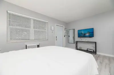 a white bedroom with a large bed and a window at Just Off Wilton Drive Apt 3 in Fort Lauderdale