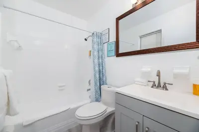 a bathroom with a toilet and a sink and a mirror at Just Off Wilton Drive Apt 4 in Fort Lauderdale