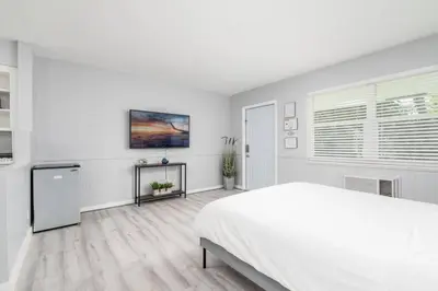 a white bedroom with a bed and a window at Just Off Wilton Drive Apt 4 in Fort Lauderdale
