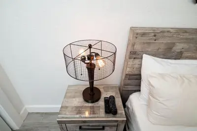 a lamp on a table next to a bed at Comfy Condos at Middle River Apt 1 in Fort Lauderdale