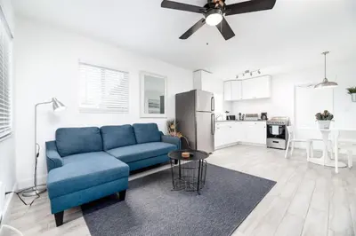 a living room with a blue couch and a kitchen at Comfy Condos at Middle River Apt 1 in Fort Lauderdale