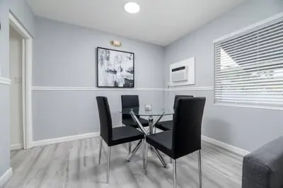 a dining room with a glass table and black chairs at The Residences at Lake Ridge Apt 3 in Fort Lauderdale